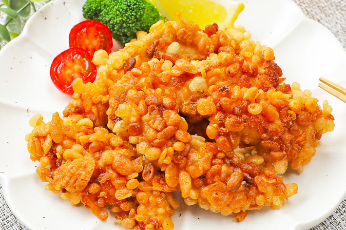 お皿に揚げた鶏肉とブロッコリー、トマトのスライス、レモンが盛り付けられている。