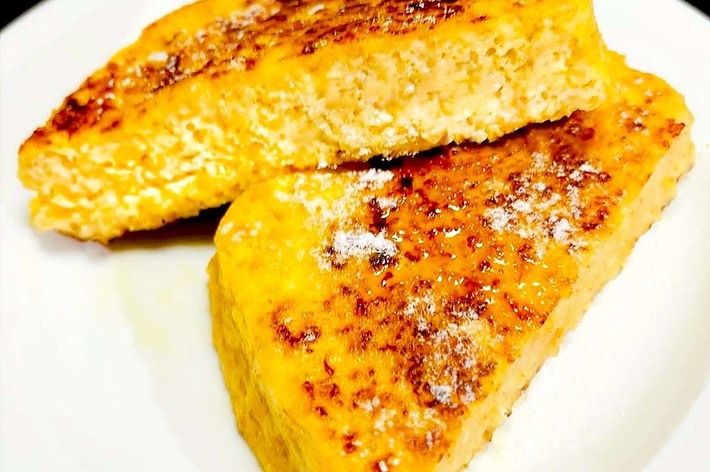 皿の上に二切れのフレンチトーストが載っています。背景には布が見えます。