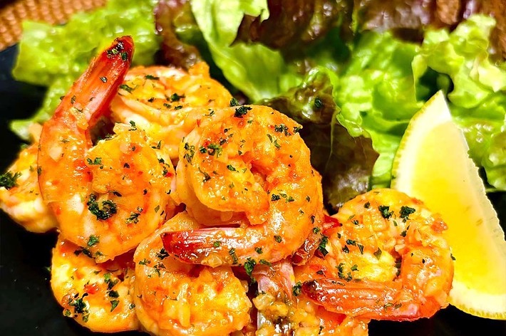 レモンとサラダを添えたガーリックシュリンプの料理。