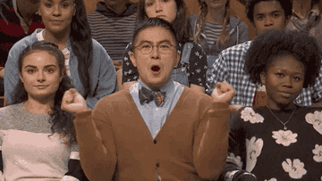 Audience member enthusiastically clapping and cheering on a TV show set, surrounded by other applauding audience members