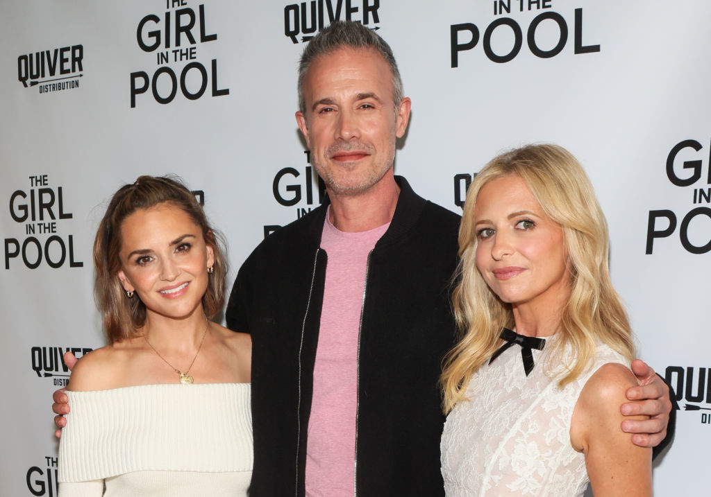Rachael Leigh Cook, Freddie Prinze Jr., and Sarah Michelle Gellar at "The Girl in the Pool" premiere. Cook wears an off-shoulder dress; Gellar in a lace dress