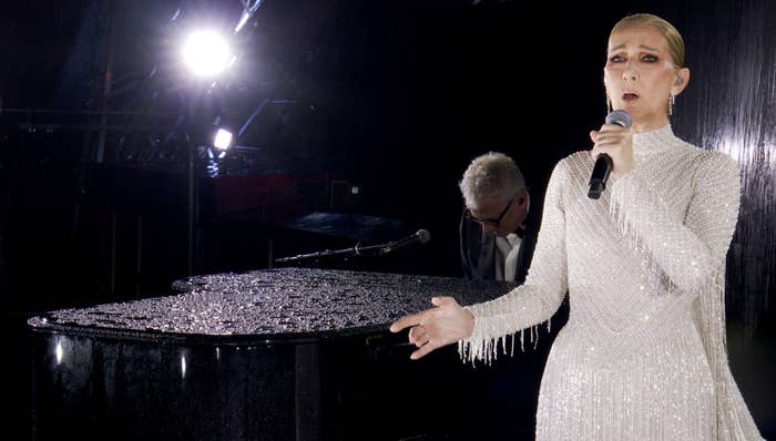 Celine Dion performs on stage in a sparkling dress, accompanied by a pianist. This image is from an article categorized as LGBT