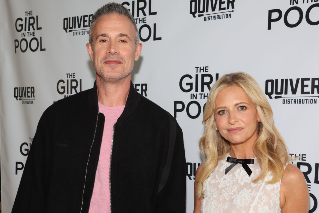 Freddie Prinze Jr. in a casual outfit and Sarah Michelle Gellar in an elegant outfit at 'The Girl in the Pool' premiere