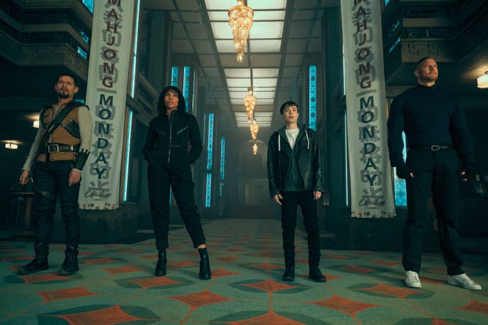 Four individuals, Jeremy Renner, Alaqua Cox, Hailee Steinfeld, and Vincent D'Onofrio, stand prominently in a grand hallway with "MAHJONG MONDAY" banners