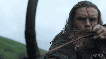 Leo Suter as Harald Sigurdsson in Netflix's &quot;Vikings: Valhalla&quot; pulling a bowstring, aiming an arrow intently