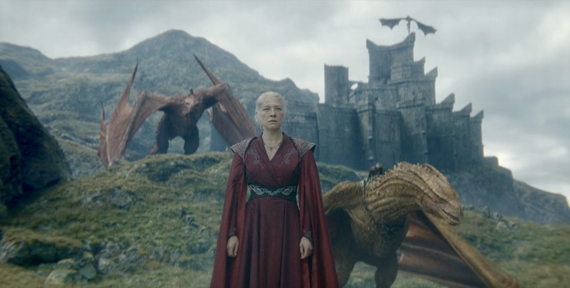 Emma D'Arcy como Rhaenyra Targaryen en vestuario medieval, con un castillo de fondo y dragones en el paisaje alrededor