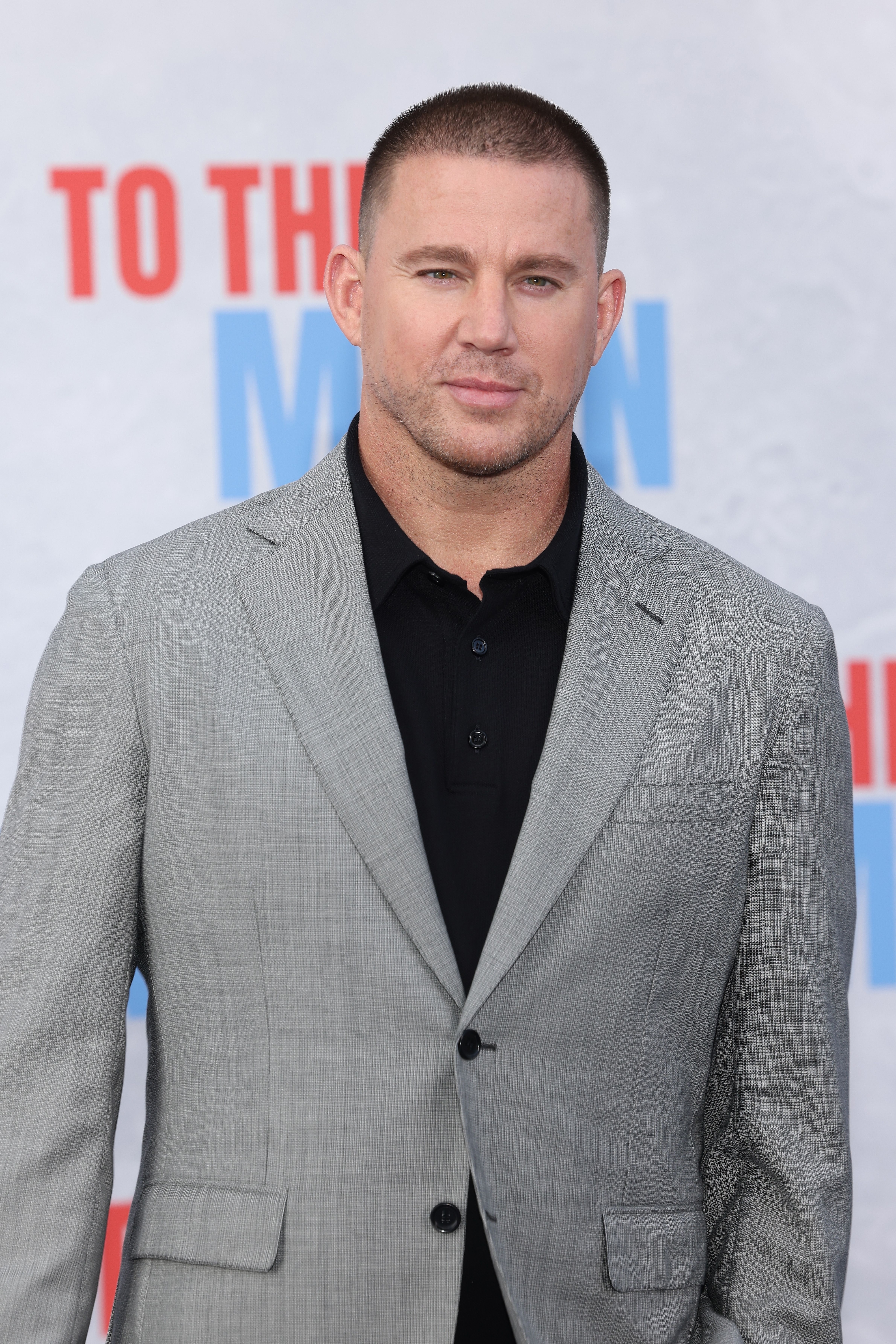 Channing Tatum poses in a grey suit and black shirt at the premiere of &quot;Fly Me to the Moon&quot;