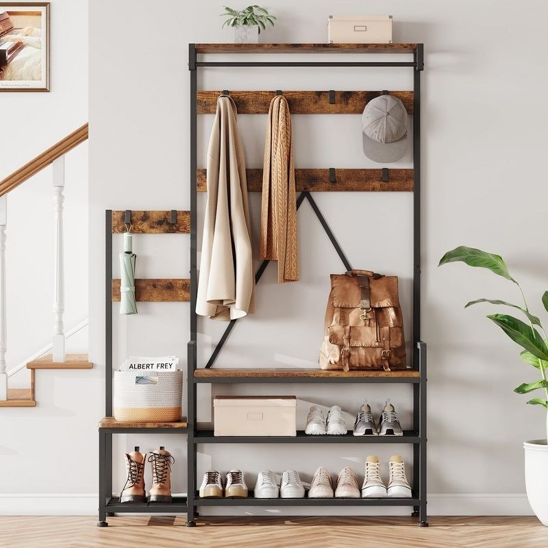 A modern entryway organizer with hooks for coats and bags, a bench for shoes, and a shelf with boxes and shoe storage. Stylish and functional home decor