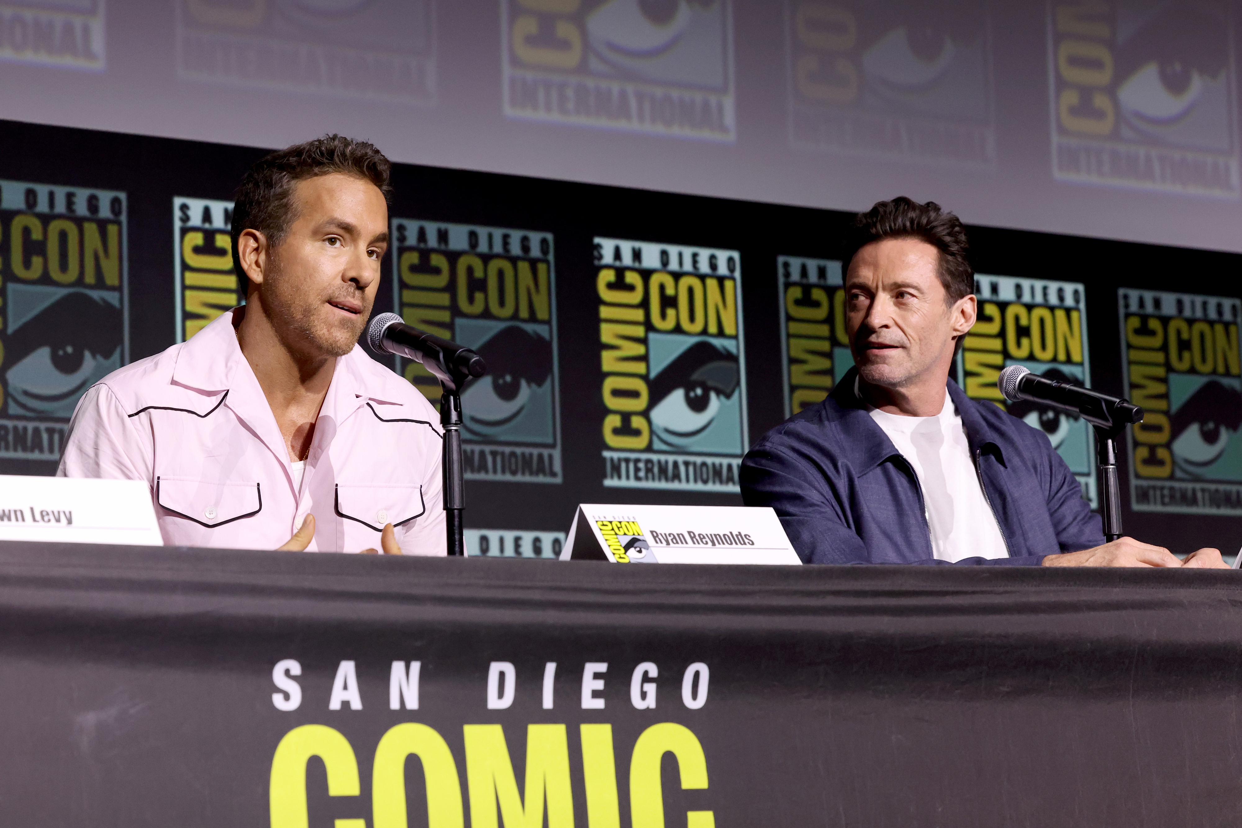 Ryan Reynolds and Hugh Jackman speaking on a panel at the 2024 Comic-Con in San Diego, California