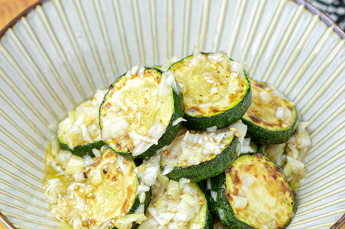 器に盛られたズッキーニのソテー。細かく刻んだ玉ねぎが上に乗っている。