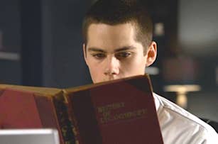 A man with short hair and a white shirt reads a book titled "History of Lycanthropy."
