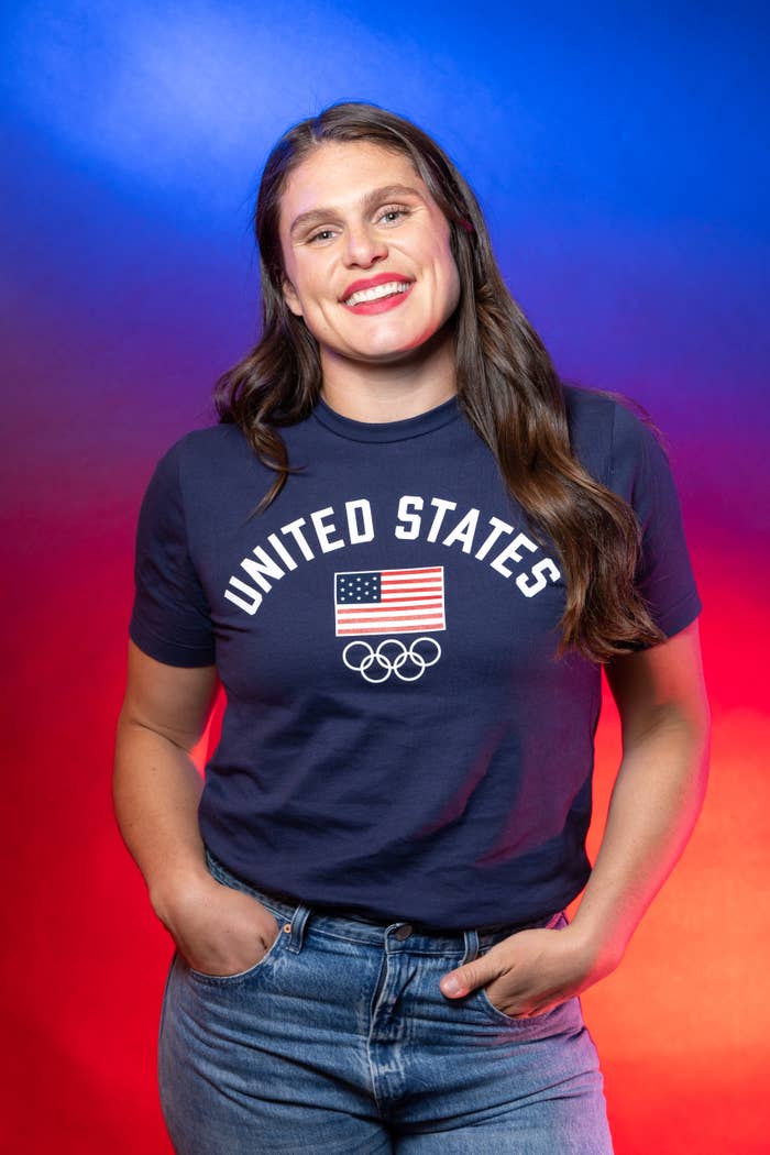United States Olympic swimmer Katie Ledecky smiles, hands in pockets, wearing a "United States" t-shirt and jeans