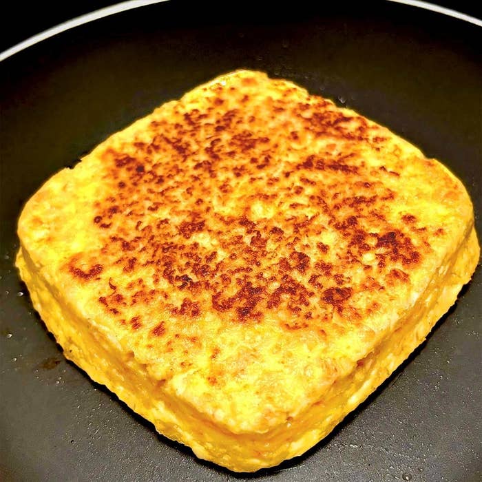 フライパンで焼かれた厚い卵焼き。