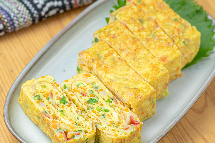 お皿に盛り付けられた具材入りの玉子焼き。食事準備が整えられている。