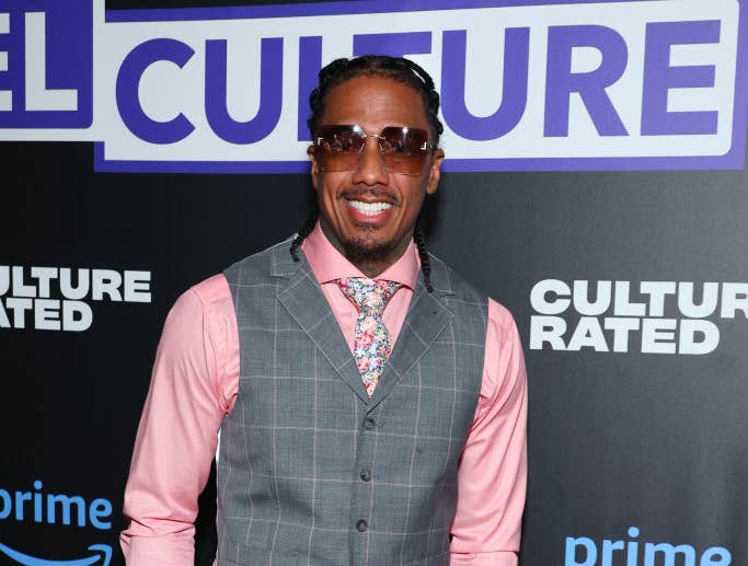 Nick Cannon is on the red carpet wearing a plaid vest suit and a pastel-colored shirt with a floral tie at a "Culture Rated" Prime event