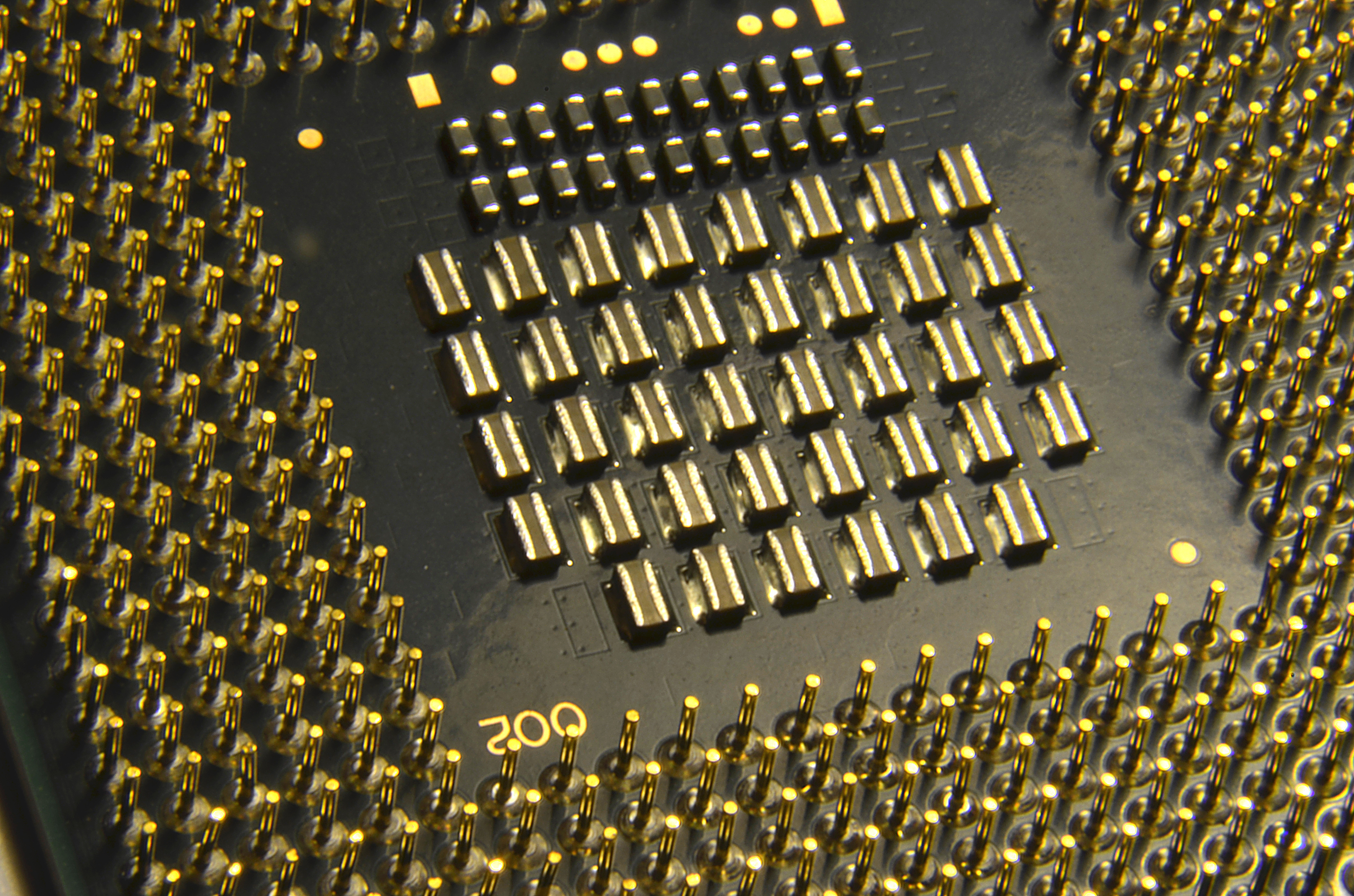 A close-up view of a computer processor's pin grid array, showing detailed pins and contact points on the chip surface