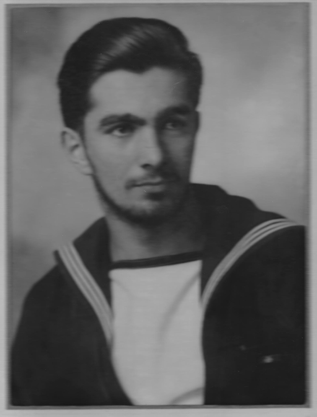 A vintage portrait of a man with short, neatly brushed hair and a trimmed beard, wearing a sailor's uniform with a white collar and dark jacket