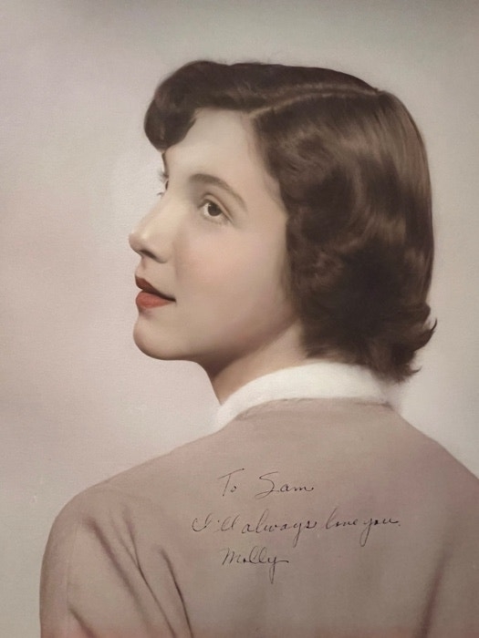 Portrait of a woman looking over her shoulder with a short hairstyle. Text on image: "To Sam, I always love you. Mollie."