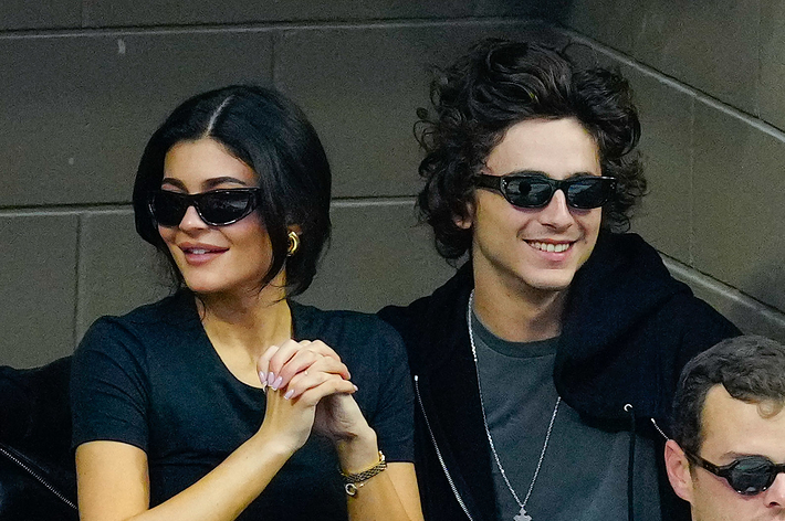 Laverne Cox, Kylie Jenner, Timothée Chalamet, and an unidentified person sitting together at an event. Cox wears a stylish outfit; Jenner and Chalamet wear casual clothes