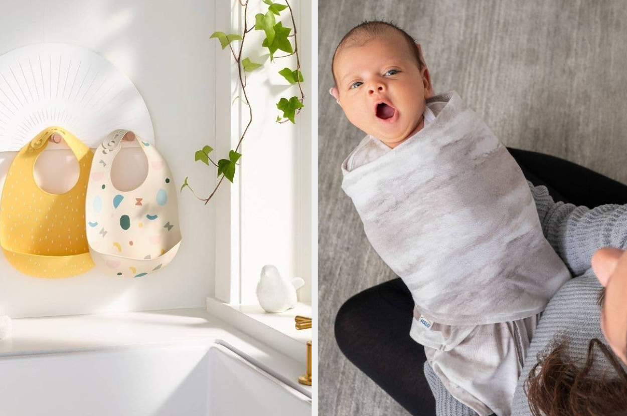 Two baby bibs hang on hooks beside a baby swaddled in a grey blanket, being held by an adult