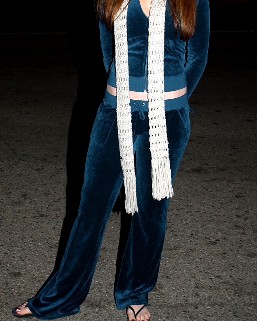A close-up image of Lindsey Lohan's velour tracksuit and flip-flops