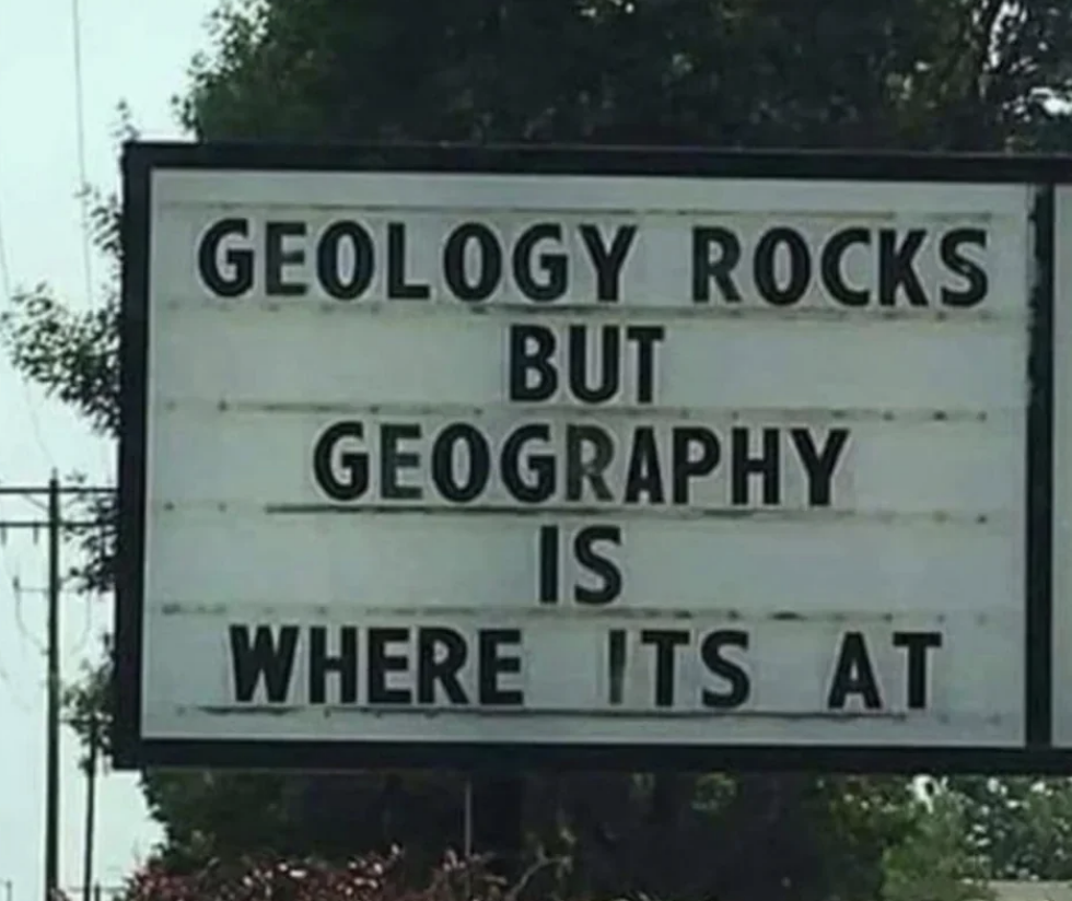 A sign reads, "Geology rocks but geography is where it's at."
