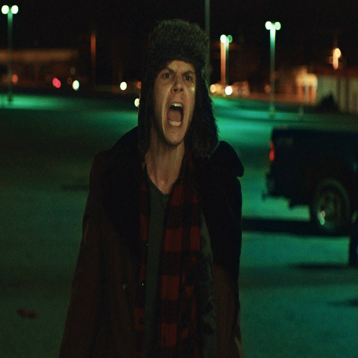 Evan Peters outside at night, wearing a winter hat and coat, yelling in a parking lot