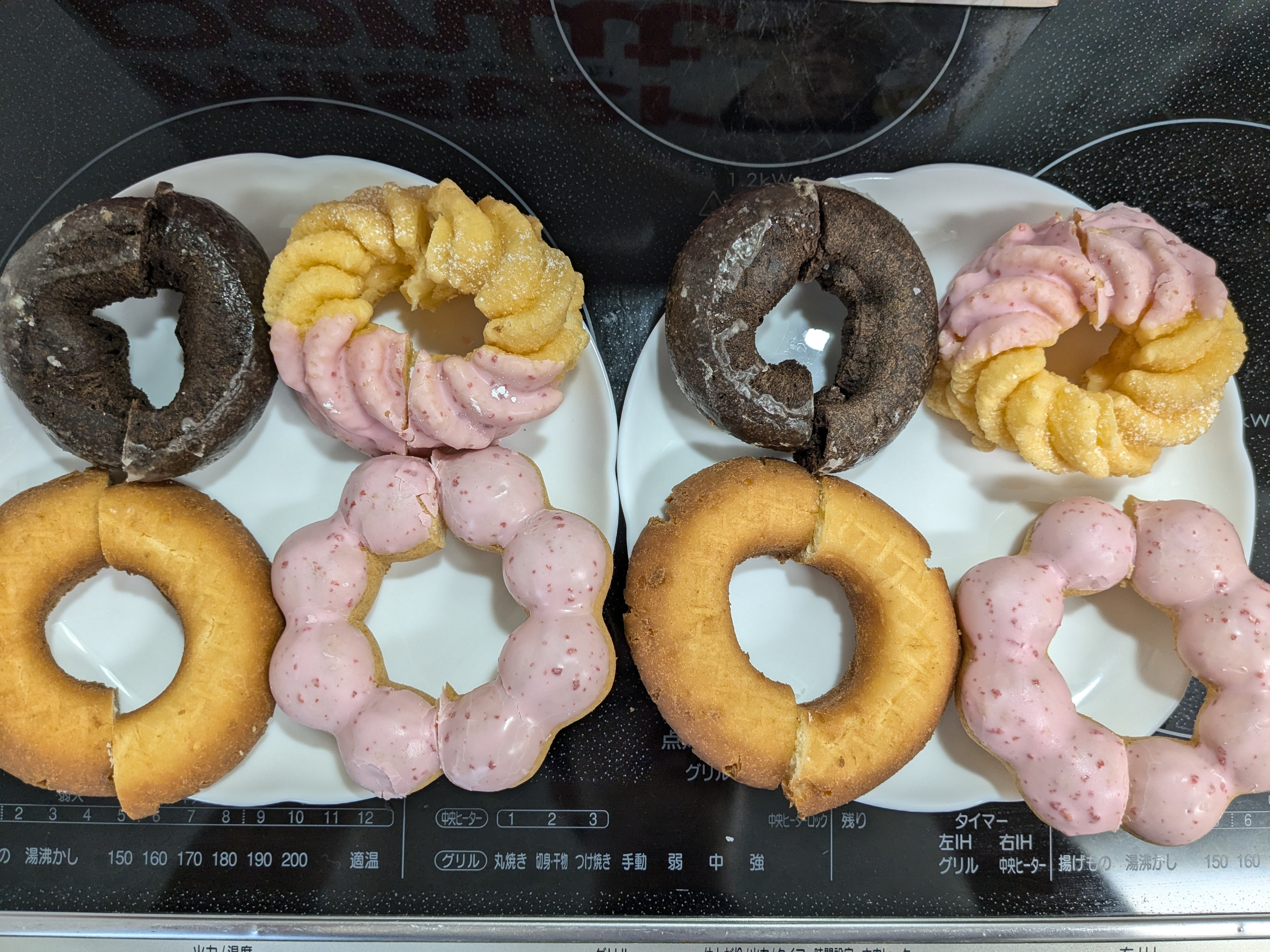 複数のドーナツが白い皿に置かれた画像。チョコレート、いちご味、プレーン味などのドーナツが見える。