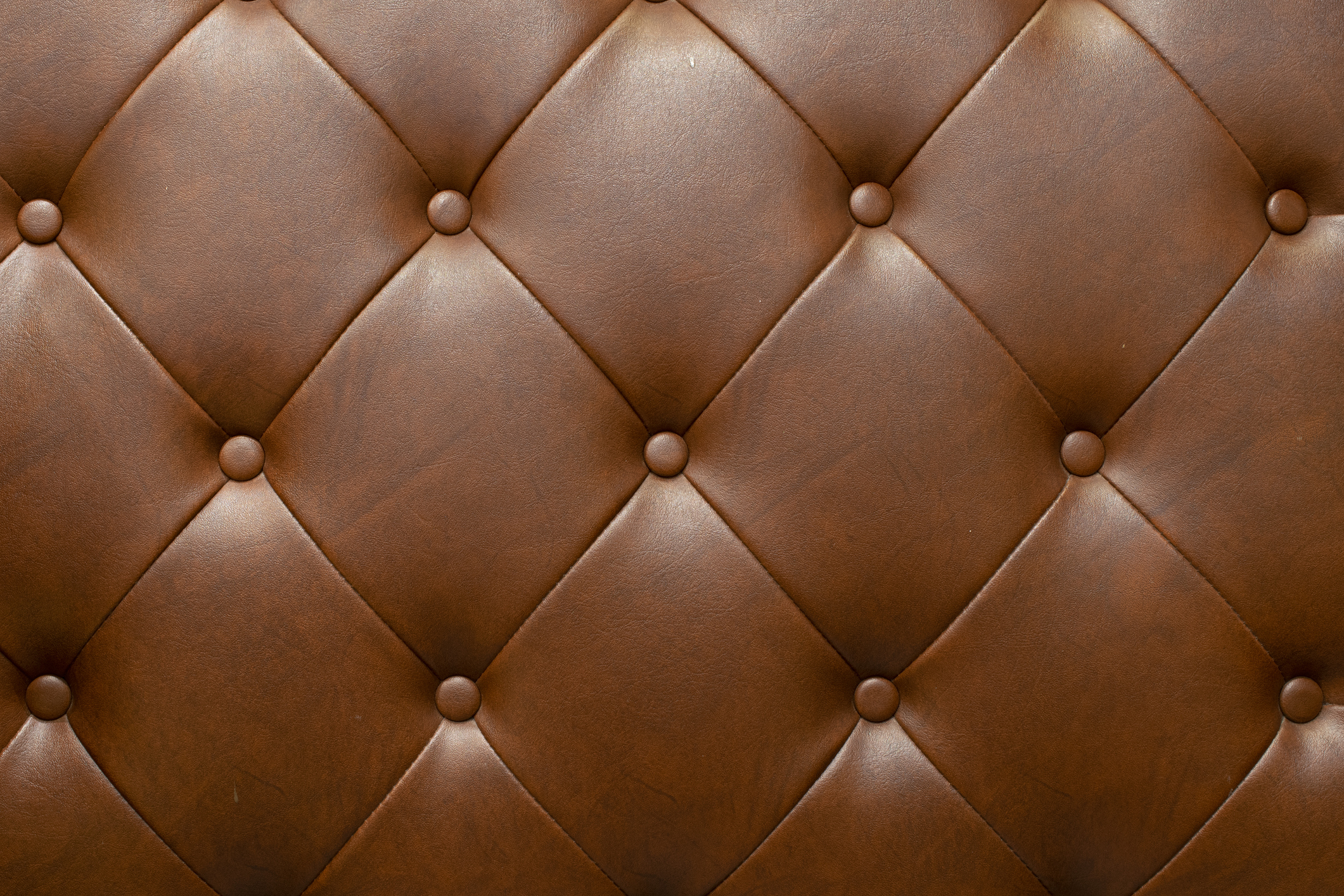 Close-up image of a tufted leather upholstery with button details