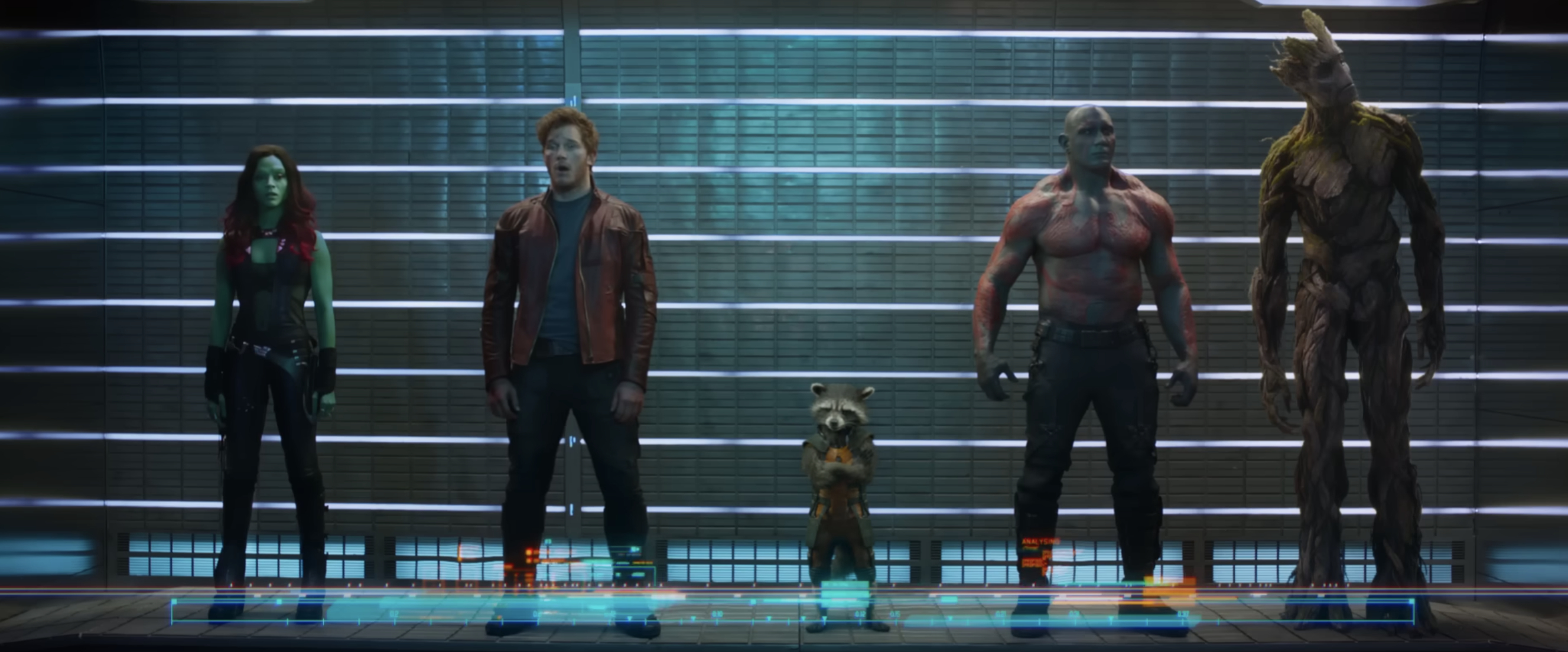 Zoe Saldana, Chris Pratt, Rocket Raccoon, Dave Bautista, and Groot stand in a lineup scene from "Guardians of the Galaxy," wearing their signature costumes