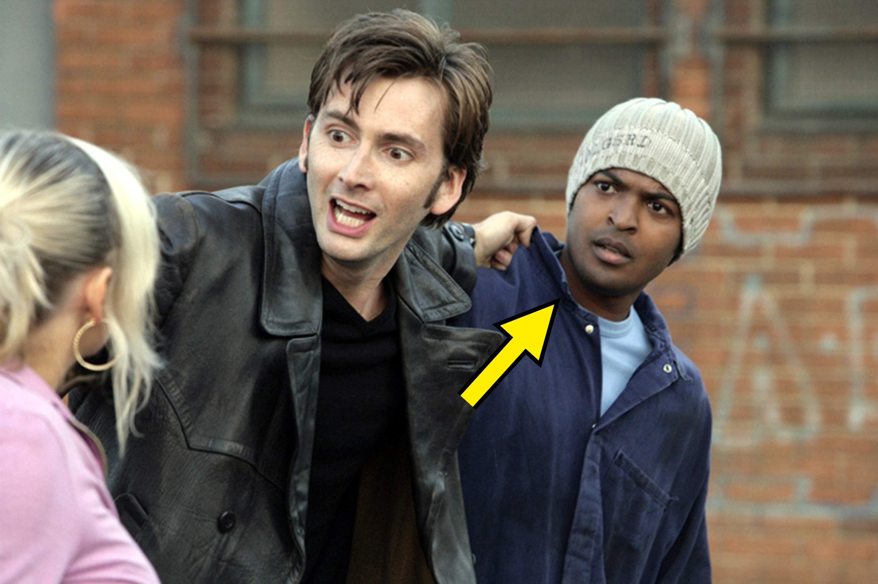David Tennant and Noel Clarke in a dramatic scene, with David in a black leather jacket. David is speaking intensely to a blonde and Noel, who's listening intently
