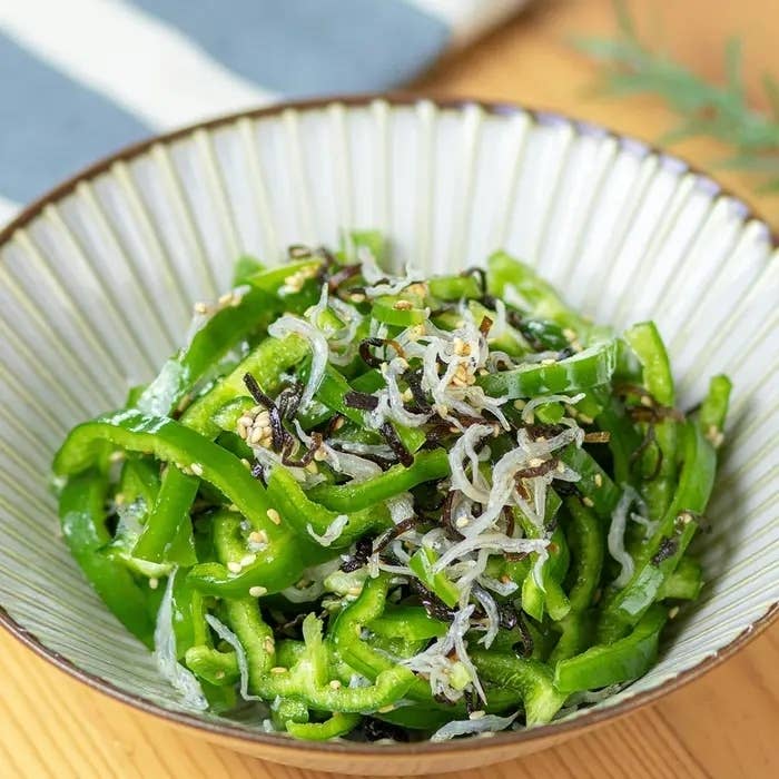 皿に盛られたピーマンの和え物。上にはごまや小魚がトッピングされている。