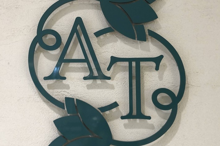 会社のロゴ、「A」と「T」がデザインされた金属の装飾。