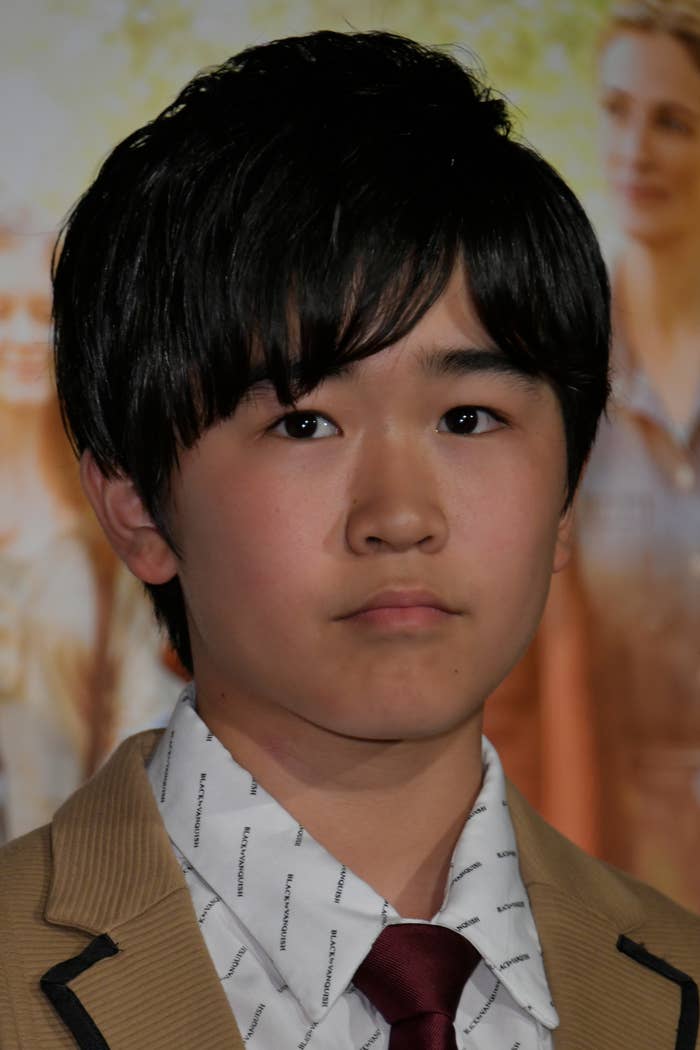 若い男性が背後にぼやけた背景の前でポーズをとっています。