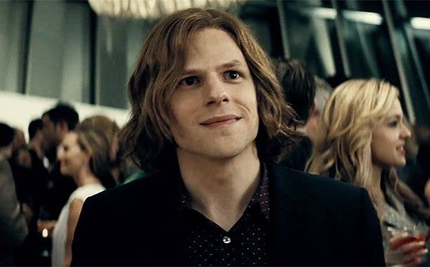Jesse Eisenberg, in a crowd, wearing a dark blazer over a polka-dot shirt, at a formal event