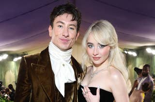 Barry Keoghan in a Victorian-inspired outfit and Sabrina Carpenter in a strapless gown with a voluminous blue train at a formal event
