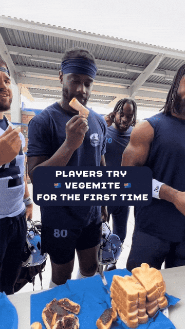 Football players try Vegemite for the first time, holding slices of bread with Vegemite spread. The text reads: "Players try Vegemite for the first time."