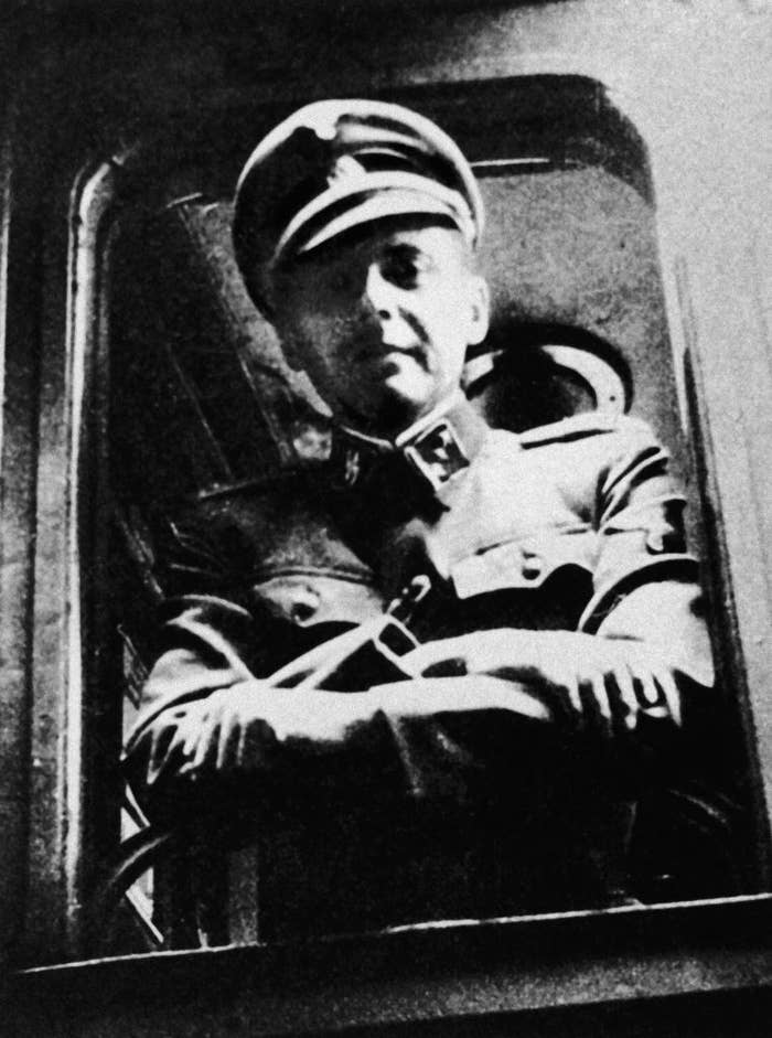 I don't know who this is. The image is of a person in military uniform, standing at the window of a train, with arms crossed