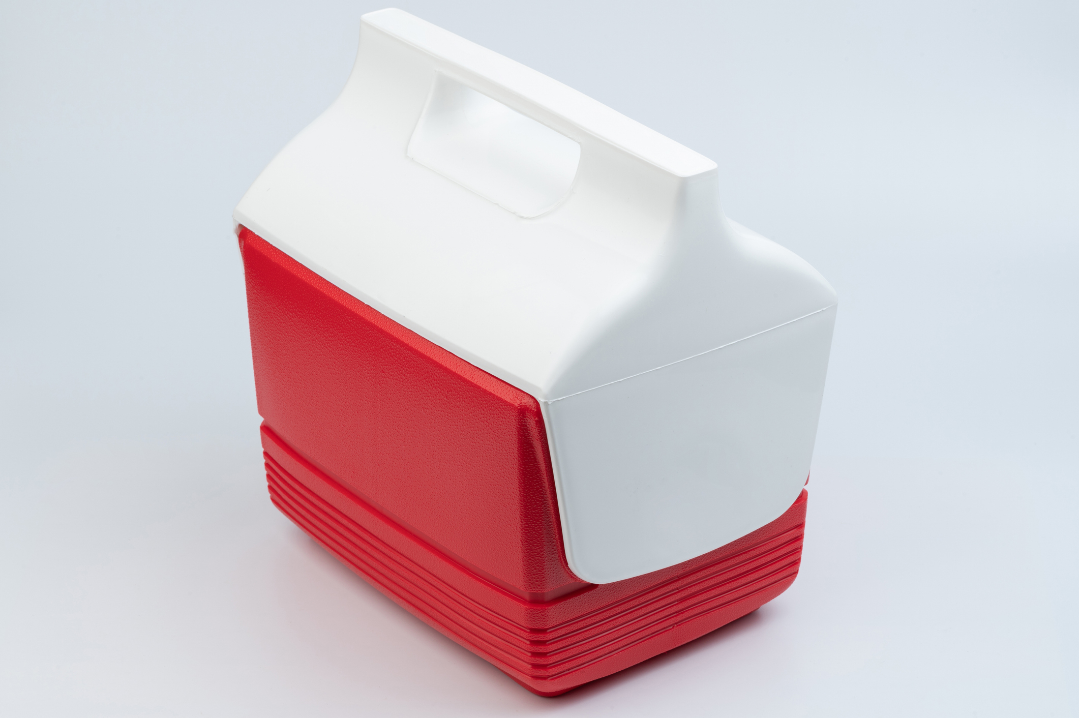 Plastic portable cooler with a white top section and a red bottom section, photographed against a plain background