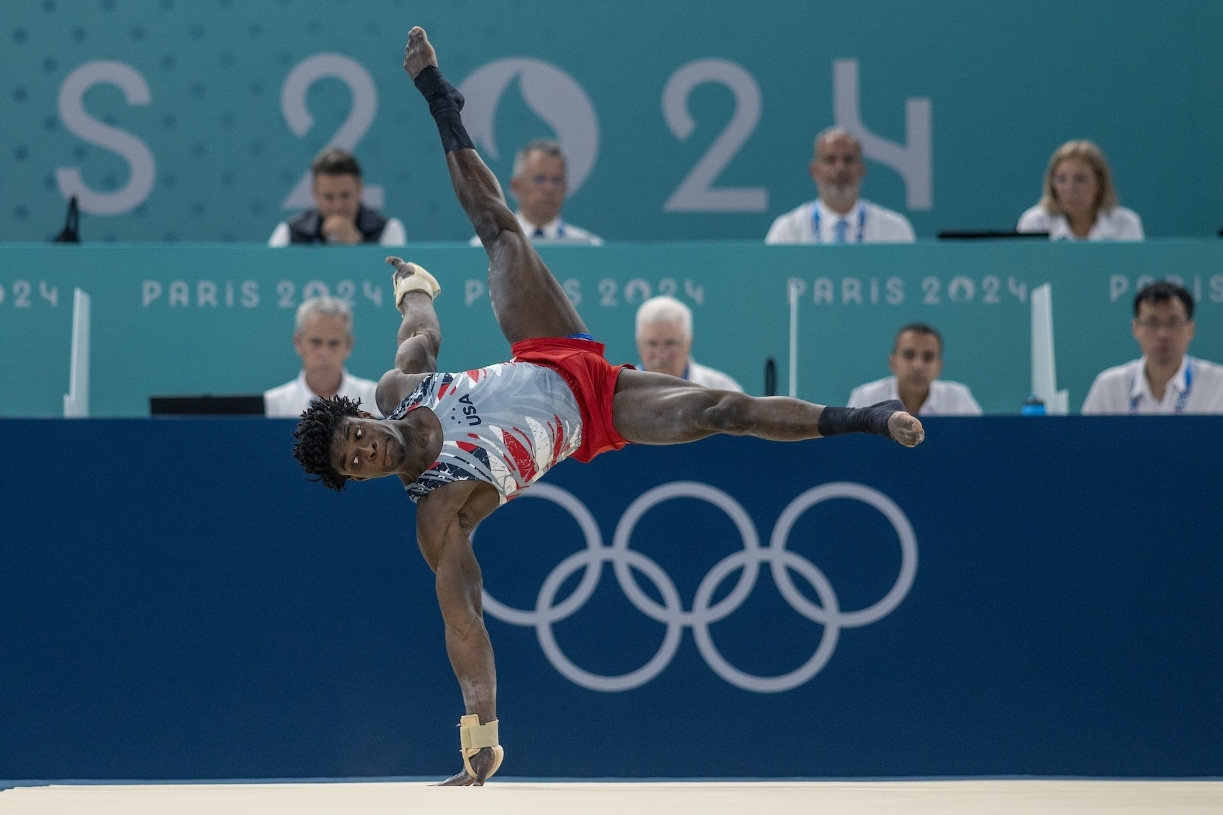 Gymnast performs a floor routine at Paris 2024 Olympics while judges watch