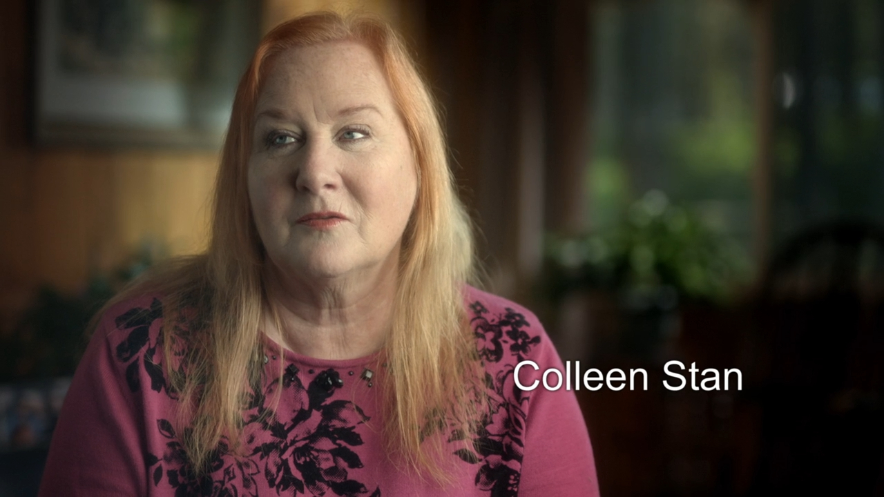 Colleen Stan is sitting indoors, wearing a patterned top. Her name is displayed in the image