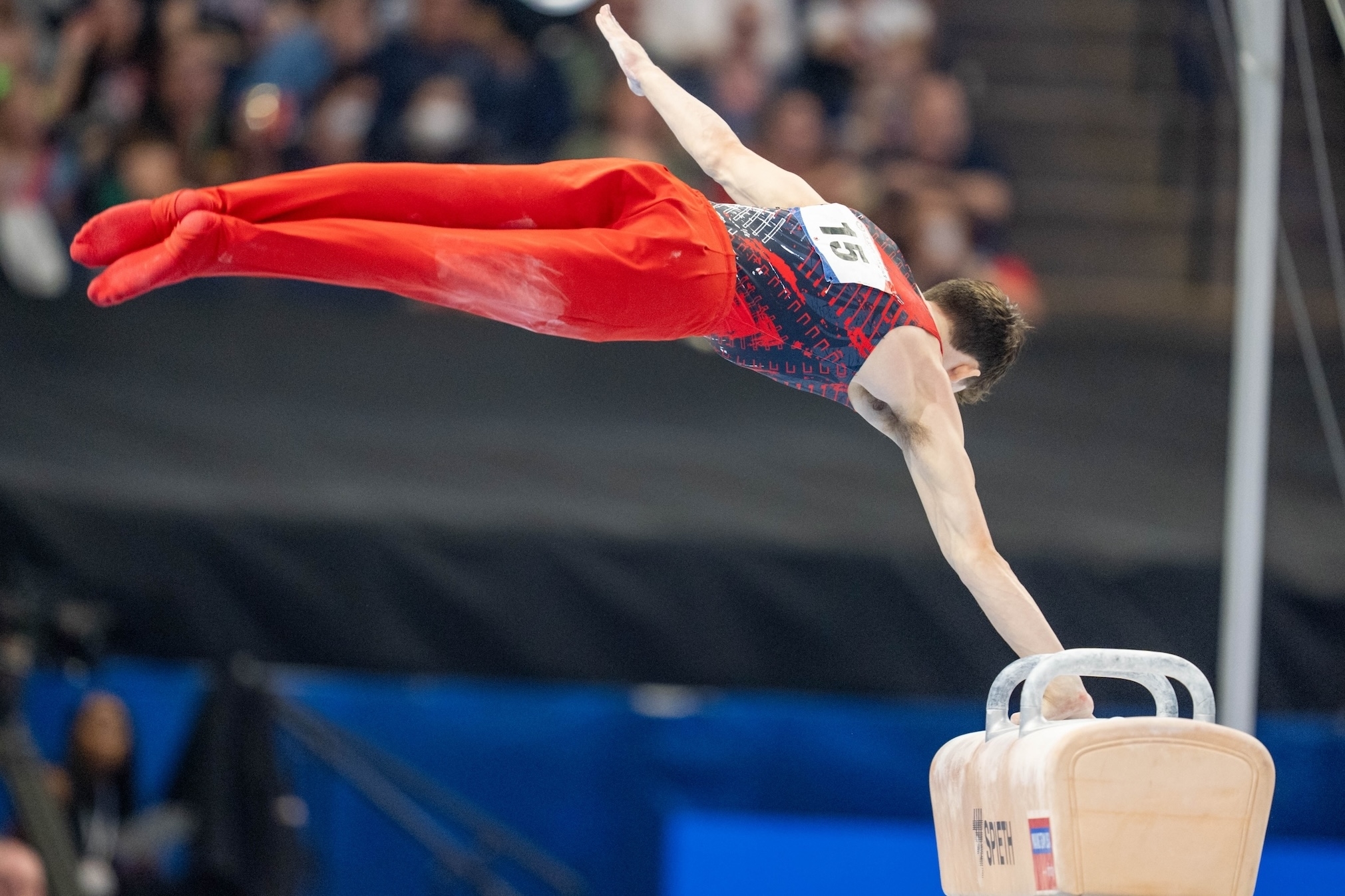 A gymnast performs a pommel horse routine at a competition