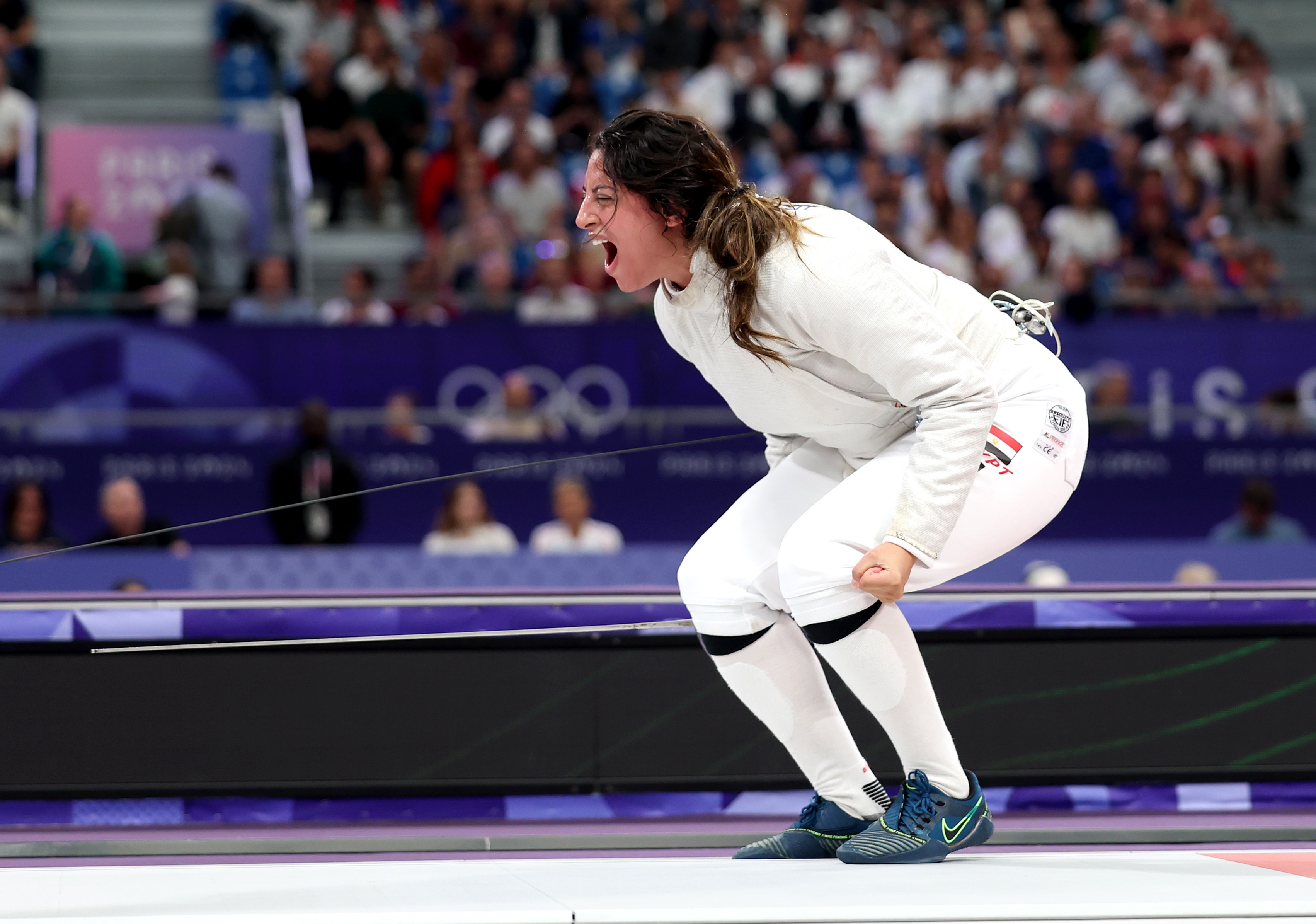 Fencer Maria Belen Perez Maurice celebrates passionately on the piste during the Tokyo 2020 Olympics, wearing her fencing uniform