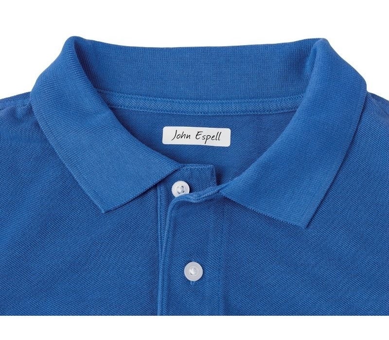 Close-up of a blue polo shirt with a collar and buttons, featuring a label that says &quot;John Espell.&quot;