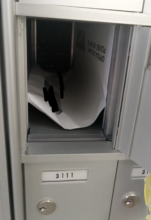A photograph of a mail locker labeled 3111 with a crumpled letter inside
