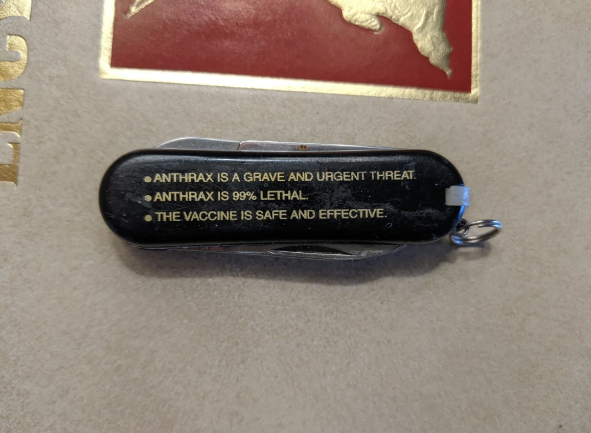 A black pocket knife with the text: "Anthrax is a grave and urgent threat. Anthrax is 99% lethal. The vaccine is safe and effective."