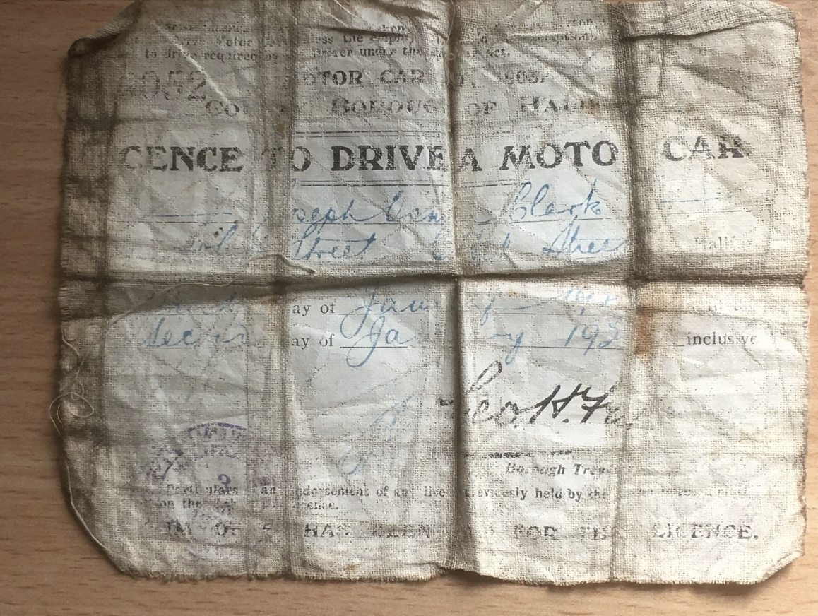 An old, worn driver's license with faded text, issued on January 17, 1920