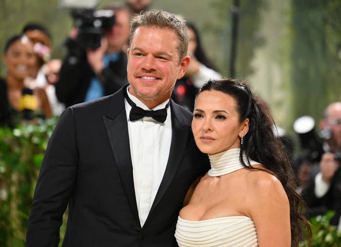 Matt Damon in a black tuxedo with a bow tie and Luciana Barroso in a strapless dress with a high-neck collar, posing at a formal event