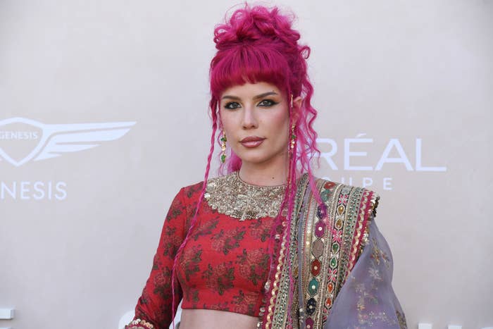 Halsey poses for photos on a red carpet, wearing a traditional-style outfit with intricate patterns and embellishments