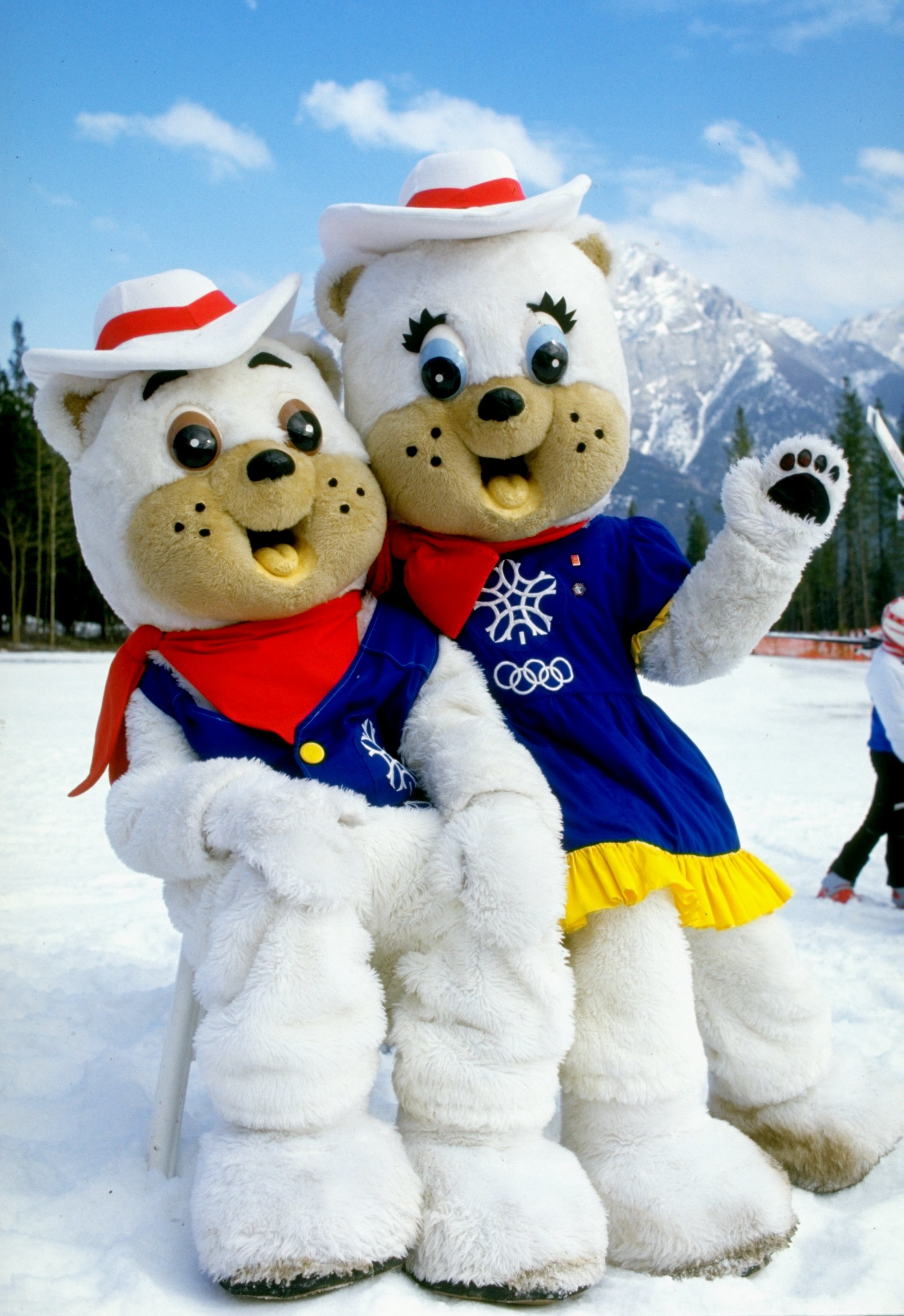 two bear mascots wearing clothes in the mountains